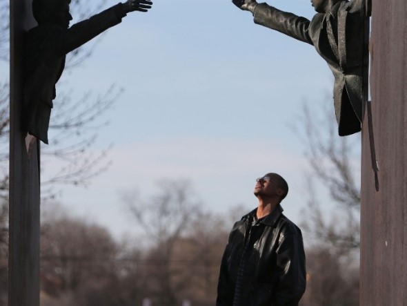 Joseph Reese of Indianapolis looks up at a statue depicting Martin Luther King Jr. and Robert F. Kennedy at MLK Park at 17th & Broadway. ROBERT SCHEER/THE STAR